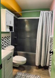een badkamer met toilet en douchegordijn bij Key Lime Cottage - waterfront in Crystal River +23 foto's