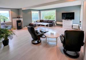 a living room with chairs and a couch and a table at Fjellhagen - Geirangerfjord view in Hellesylt