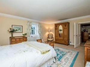 a bedroom with a large white bed and a desk at Country Home on Private Estate in Minishant
