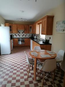 a kitchen with a table and chairs and a refrigerator at Rossole Cottage in Enniskillen