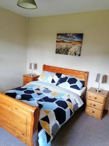 a bedroom with a bed and two night stands with lamps at Rossole Cottage in Enniskillen