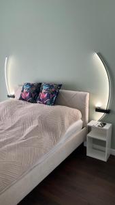 a bed in a room with a white wall at Apartament Rytm - Metro Kabaty in Warsaw +11 photos