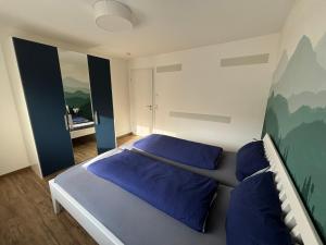 a bedroom with a bed with blue pillows on it at Ferienwohnung Gergert Nr 5 in Löwenstein
