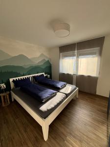 a bedroom with a bed with a mountain mural on the wall at Ferienwohnung Gergert Nr 5 in Löwenstein