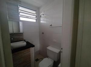 a bathroom with a toilet and a sink and a window at Apartamento no Centro in Piracicaba +6 photos