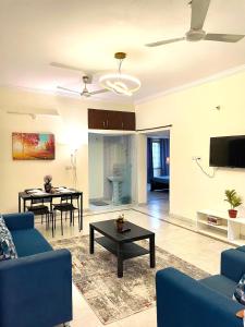 a living room with a blue couch and a table at Aero homes in Madhapur