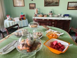 a table topped with plates of pastries and fruit at B&B I versi del mare in Roseto degli Abruzzi