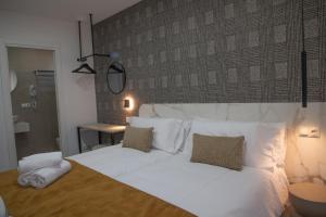 a bedroom with a large white bed with two pillows at Vivienda Fermina Padron in Padrón
