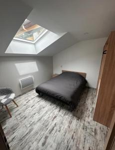 ein Schlafzimmer mit einem Bett und einem Dachfenster in der Unterkunft Ô Ptit Bouleau in Buhl-Lorraine