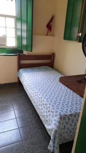 帕拉蒂Casa Completa Centro Histórico Paraty RJ的窗户客房内的小床