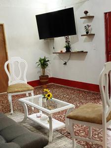 a living room with a tv and two chairs and a coffee table at Casa De Campo "Las Chispas" in Medellín