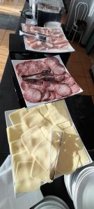 een tafel met verschillende soorten kaas en vlees bij Hotel Delfino in Milano Marittima +29 foto's