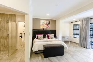 a bedroom with a large bed and a shower at 8 On Eagle Bed & Breakfast Room 2 in Port Shepstone