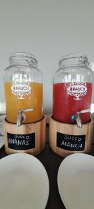 twee potten gevuld met verschillend gekleurde dranken bovenop dozen bij Hotel Delfino in Milano Marittima