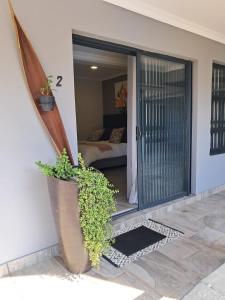a porch with a potted plant on the side of a house at 8 On Eagle Bed & Breakfast Room 2 in Port Shepstone