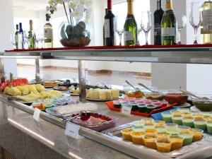 um buffet com muitos tipos diferentes de alimentos e garrafas de vinho em Park L'acqua di roma - Cozinha completa em Caldas Novas