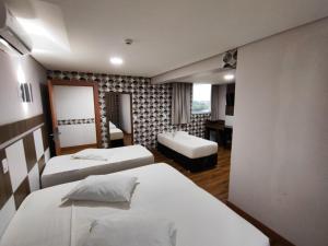 a hotel room with two beds and a mirror at Hotel Maestro Executive Toledo in Toledo +23 photos