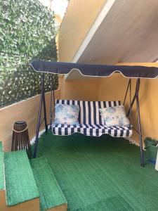 ヴィッラシミーウスにあるVillasimius Villetta indipendenteのテーブルの下にベンチがあり、その下に枕が2つある +8枚の写真