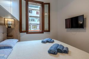 1 dormitorio con 1 cama y 2 pares de toallas en Perseo case vacanze Mameli Apartment, en Olbia