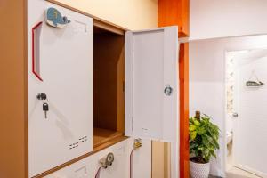 a kitchen with white cabinets and a door at Sweett Lemon Hostel in Patong Beach