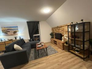 a living room with a couch and a table at FeWo Foorden Wohnglück 2 in Hesel