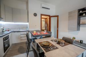 cocina con mesa y sillas y comedor en Perseo case vacanze Mameli Apartment, en Olbia