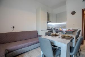 una sala de estar con una mesa y un sofá en Perseo case vacanze Mameli Apartment, en Olbia 17 fotos más