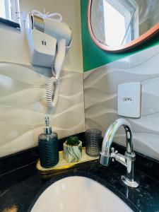 a bathroom with a sink and a phone on the wall at Stúdio equipado em Xerém - St 6 in Xerém