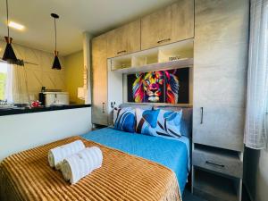 a bedroom with a bed with a lion painting on the wall at Stúdio equipado em Xerém - St 6 in Xerém