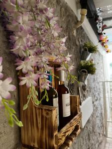 a bunch of bottles of wine on a wall with flowers at Intellihost - Casa Giulietta Lonato del Garda in Lonato