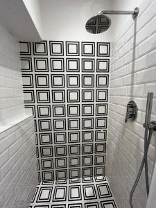 a shower with a black and white tile wall at Casa Giulietta - Lonato del Garda in Lonato del Garda +28 photos
