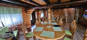 a long wooden table and chairs in a log cabin at Cabana dintre Salcami in Durau