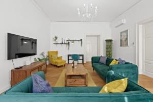 a living room with green couches and a tv at Apartment Augier - City Centre - 100sqm - Free Parking nearby in Pula