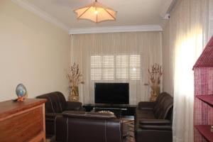 a living room with two couches and a television at K.méléon-Hôtel in Ivato