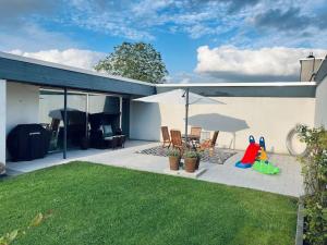 a house with a patio with chairs and an umbrella at Charmante 2-Zimmerwohnung im Luftkurort Lippe in Lage