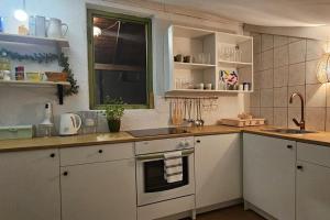 a kitchen with white cabinets and a sink at Stone Three bedroom house with rooftop terrace in Jezera