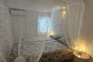 a bedroom with a bed with a mosquito net at Stone Three bedroom house with rooftop terrace in Jezera