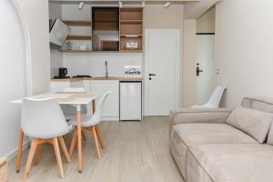 ドゥラスにあるFluctus Apartmentsのソファとテーブルと椅子のあるリビングルーム