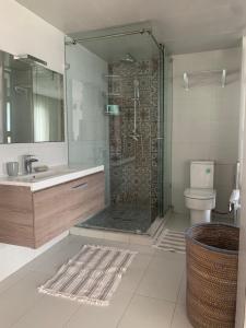 a bathroom with a shower and a sink and a toilet at Villa Jackbeach front mer in Dar Bouazza