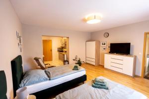 a bedroom with a bed and a flat screen tv at Pension Altsprucke in Guben