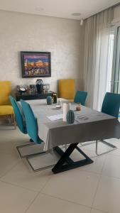 a dining room with a table and blue chairs at Villa Jackbeach front mer in Dar Bouazza +15 photos