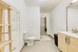 ein weißes Badezimmer mit Toilette und Waschbecken in der Unterkunft L'Elégant de Paris - Villepinte - Paris in Villepinte + 14 Fotos