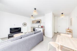 ein Wohnzimmer mit Sofa und Tisch in der Unterkunft L'Elégant de Paris - Villepinte - Paris in Villepinte