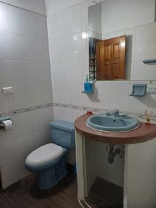 a bathroom with a blue toilet and a sink at Yawira House in Leticia