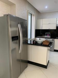 a kitchen with a stainless steel refrigerator and a counter at Villa Jackbeach front mer in Dar Bouazza