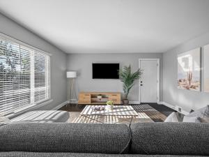 a living room with a couch and a tv at Stylish and Bright 3Bd Home, Amazing Deck, Game Room, Free Parking in Pittsburgh