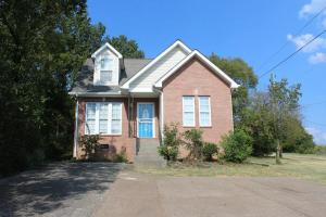a brown brick house with a blue door at Charming 3-bedroom house Scenic&Close to Downtown in Nashville