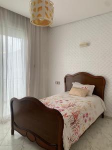 a bedroom with a bed and a chandelier at Villa Jackbeach front mer in Dar Bouazza