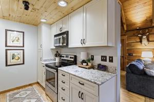 a kitchen with white cabinets and a stove top oven at Ridgeview in Blowing Rock +18 photos