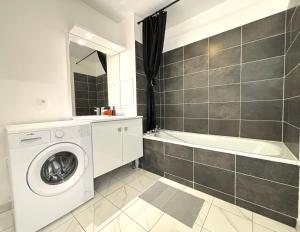 a bathroom with a washing machine and a bath tub at Cartier Disney 7min Train 6min Paris parking in Serris